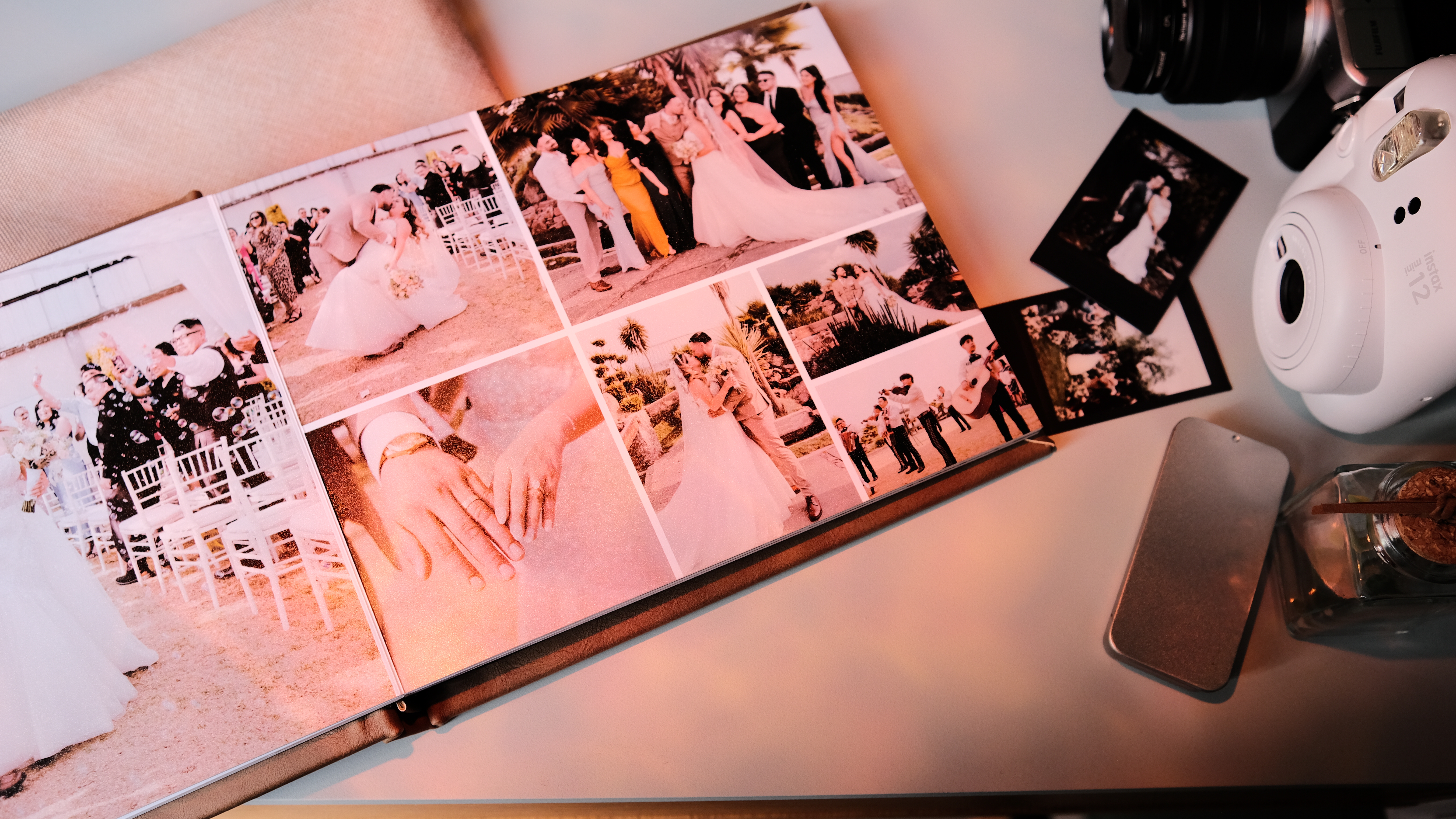 Álbum de fotos de boda abierto, mostrando diferentes momentos del evento, como parejas y celebraciones, con una cámara y algunos recuerdos cerca.